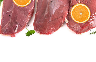 Three duck breasts with sliced oranges and some herbs