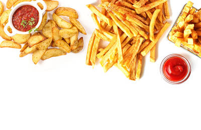 Fried potato wedges and straight french fries with two small dishes of ketchup