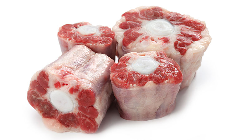 A picture of four cuts of oxtail, arranged close together.